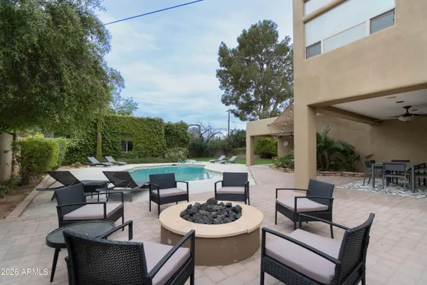 a view of a patio with couches potted plants and a large tree