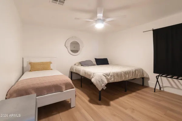 a bedroom with a bed and wooden floor
