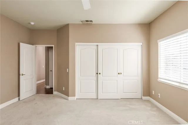 an empty room with windows and closet