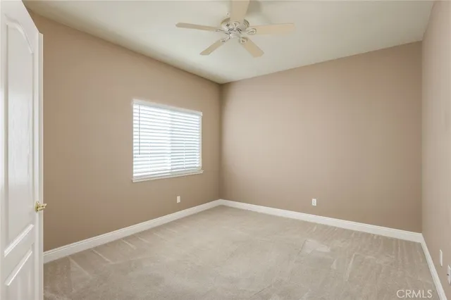 an empty room with a window and a fan