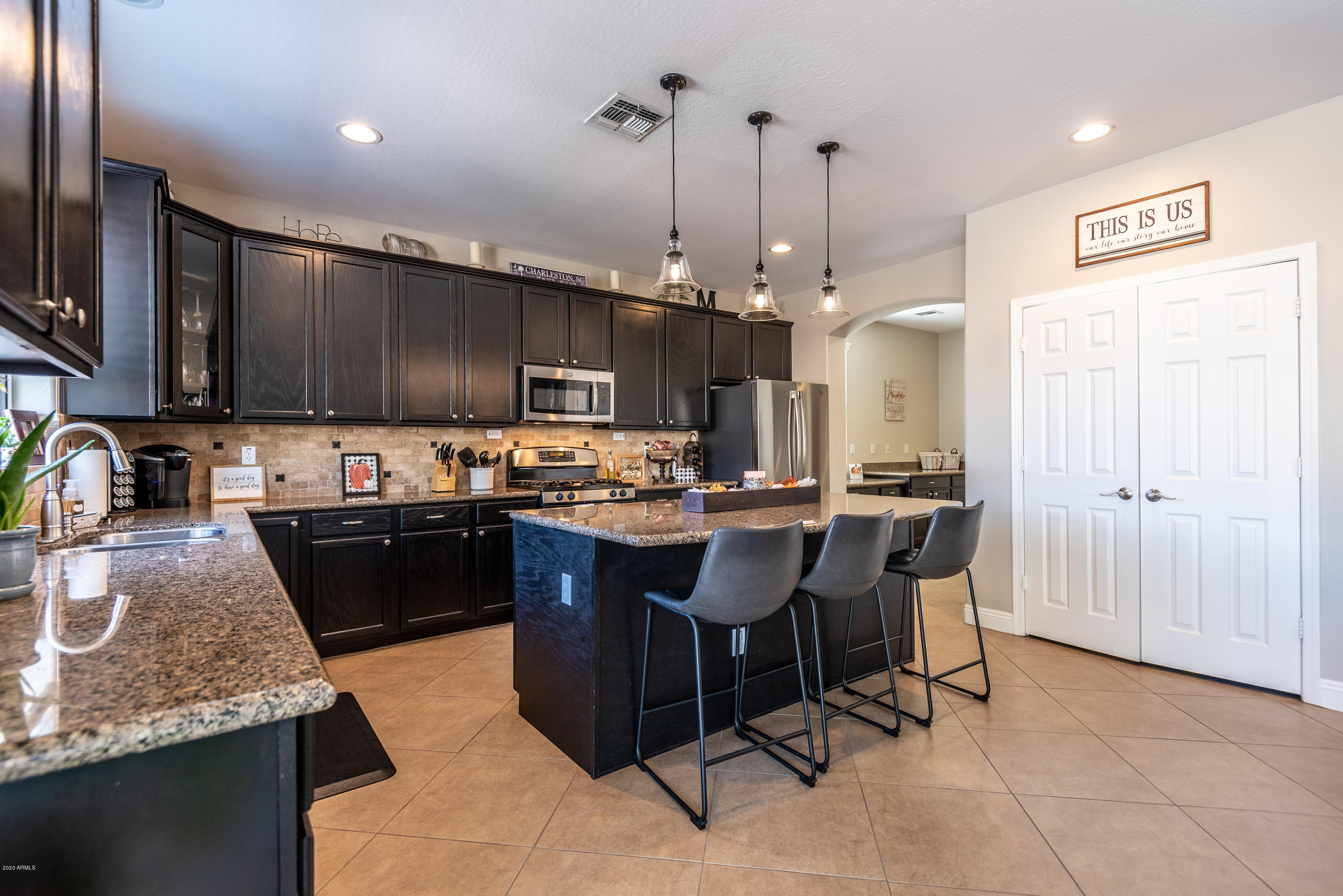 13628 West Calavar Road Surprise, AZ 85379 - Photo 12 of 48 a kitchen with kitchen island granite countertop a sink counter top space appliances and cabinets