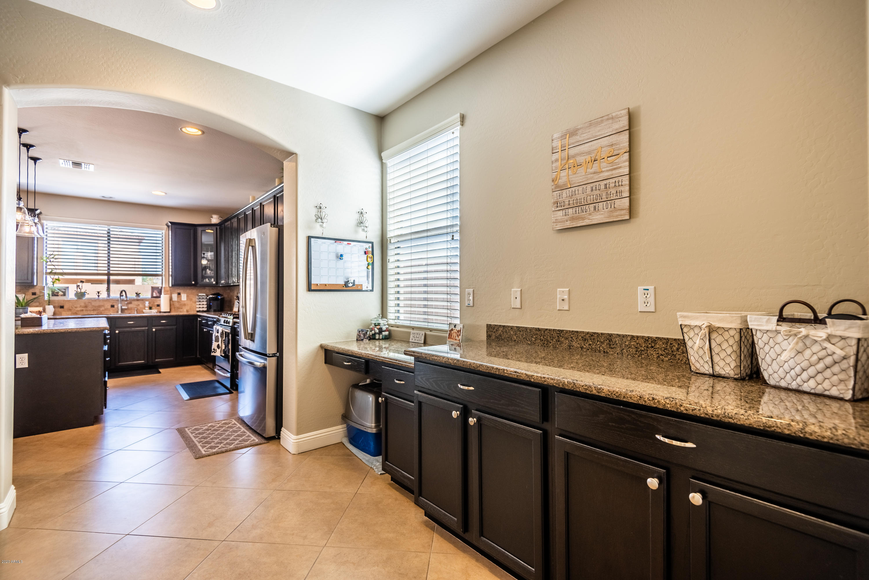 13628 West Calavar Road Surprise, AZ 85379 - Photo 15 of 48 a kitchen with stainless steel appliances granite countertop a sink dishwasher stove and refrigerator