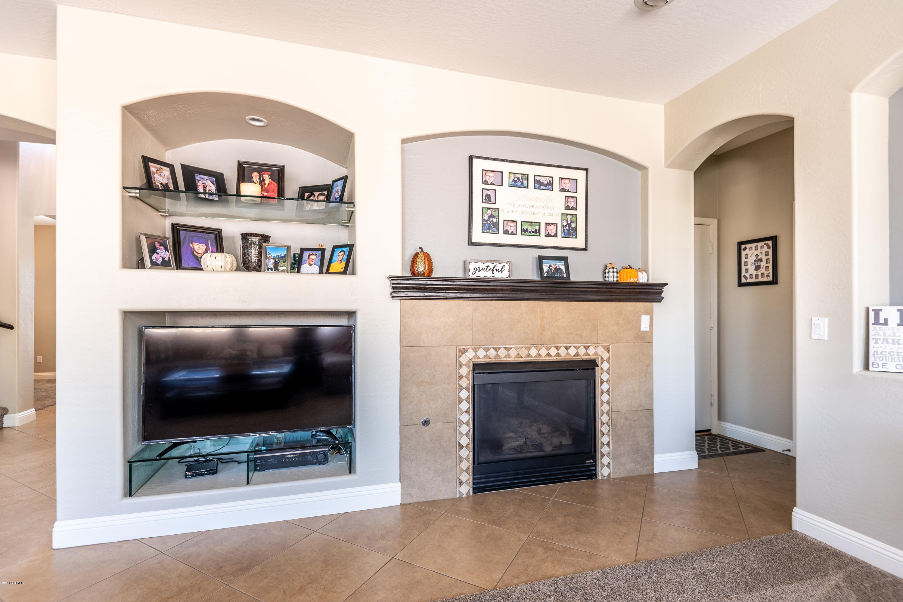 13628 West Calavar Road Surprise, AZ 85379 - Photo 20 of 48 a living room with furniture a flat screen tv and a fireplace