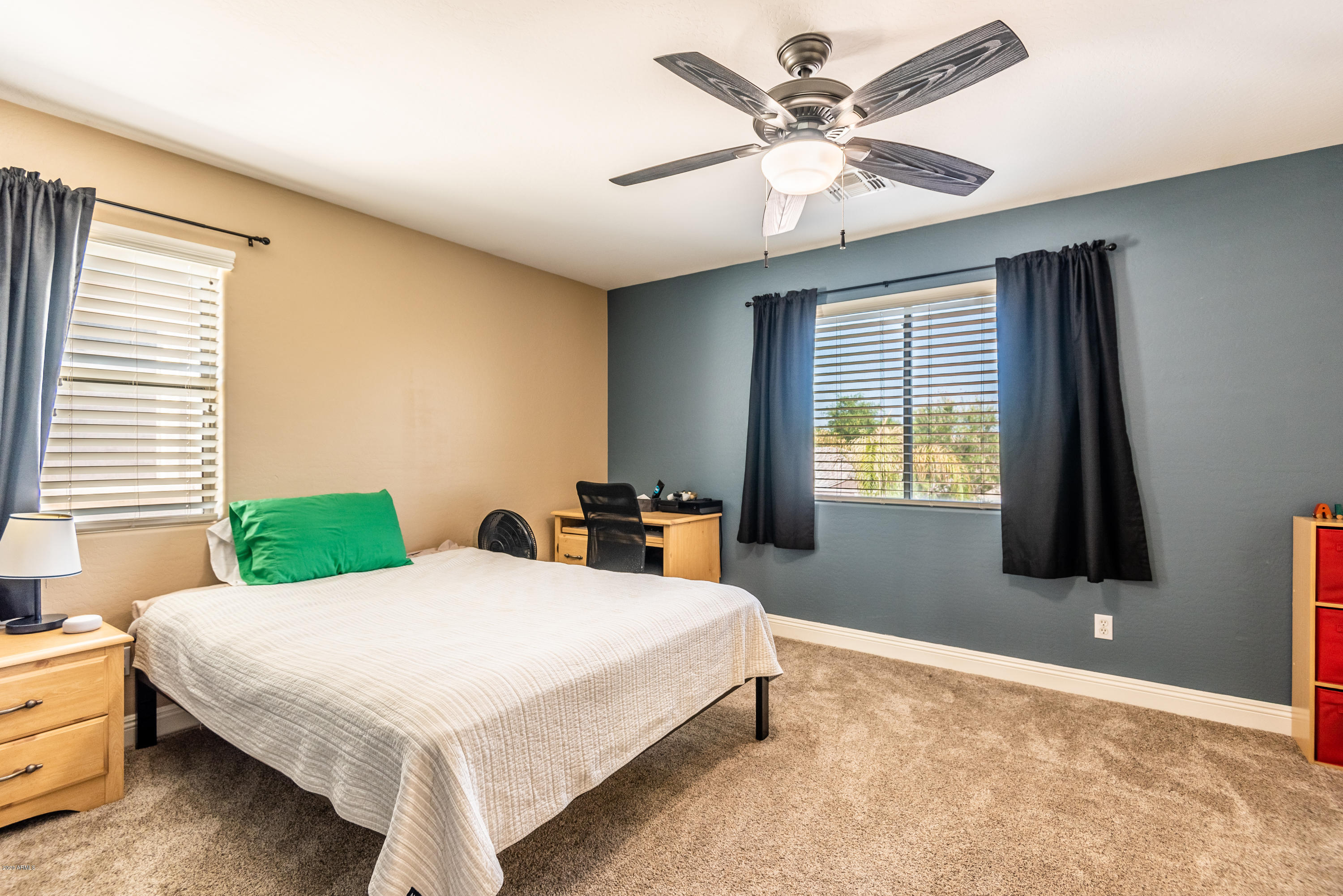 13628 West Calavar Road Surprise, AZ 85379 - Photo 36 of 48 a bedroom with a bed and a chandelier