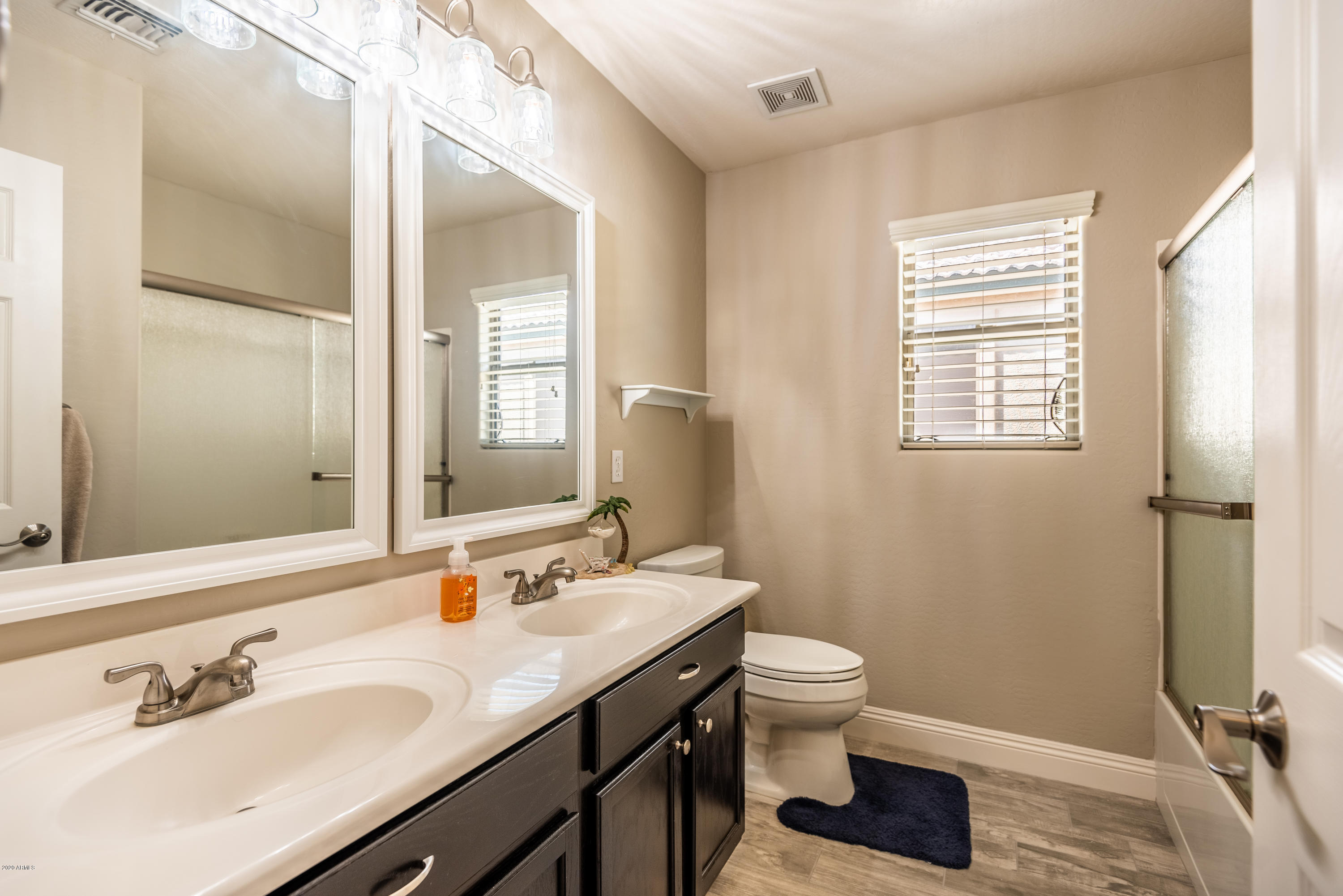 13628 West Calavar Road Surprise, AZ 85379 - Photo 38 of 48 a bathroom with a granite countertop sink toilet a mirror and shower
