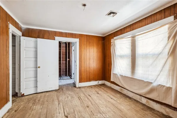 wooden floor in an empty room with a window