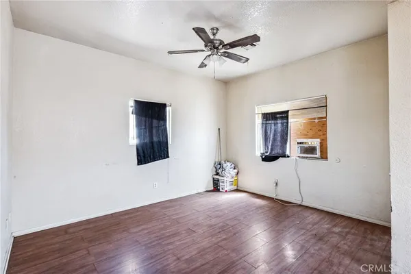 a view of a livingroom with wooden floor and a ceiling fan