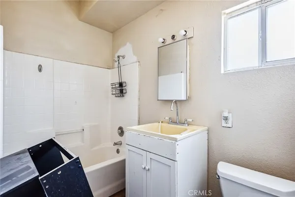 a bathroom with a sink a toilet a tub and shower