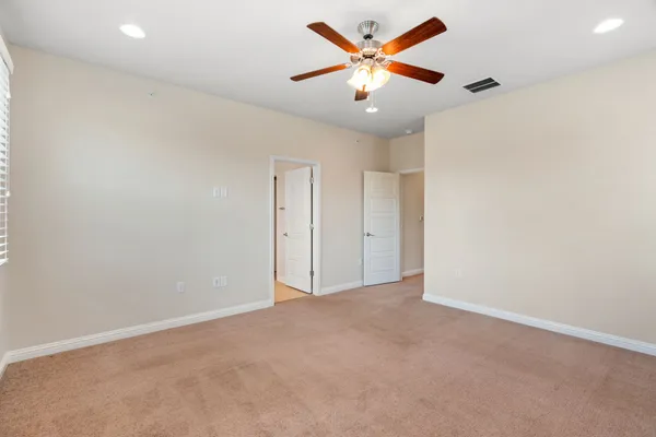 an empty room with a ceiling fan and a window