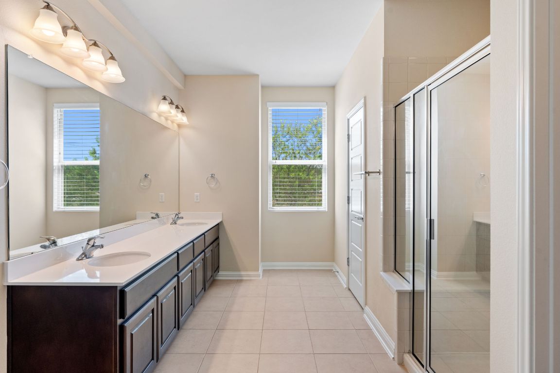 6814 East Riverside Drive, Unit 35 Austin, TX 78741 - Photo 16 of 31 a spacious bathroom with a double vanity sink a large mirror and a bathtub