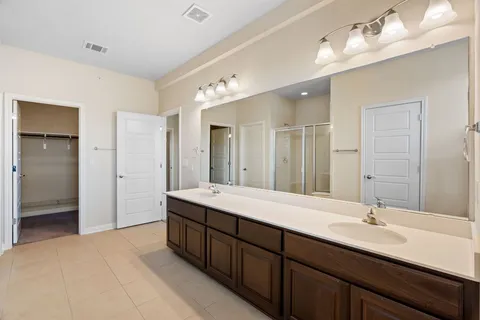 a spacious bathroom with a double vanity sink mirror and shower