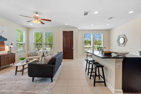 a living room with stainless steel appliances furniture and a large window
