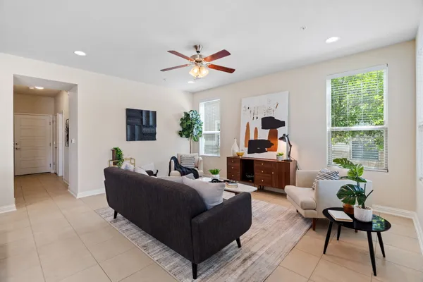 a living room with furniture a chandelier and a large window