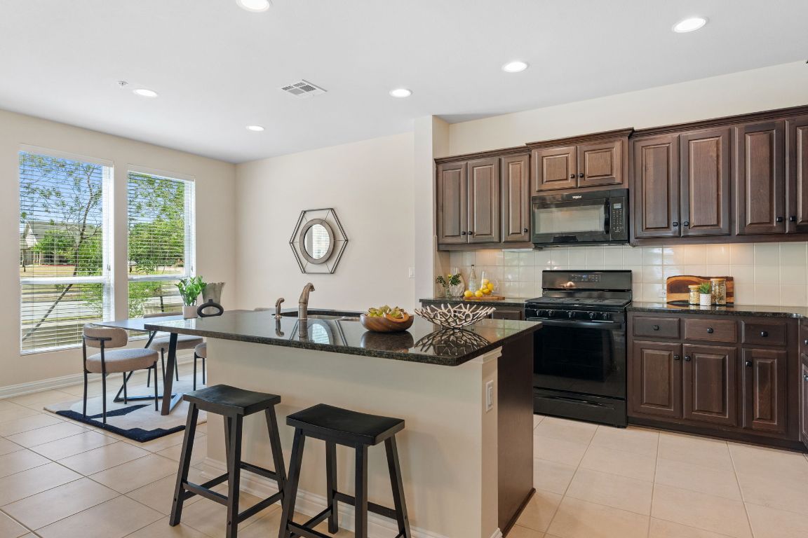 6814 East Riverside Drive, Unit 35 Austin, TX 78741 - Photo 7 of 31 a kitchen with stainless steel appliances granite countertop a stove a sink and a microwave