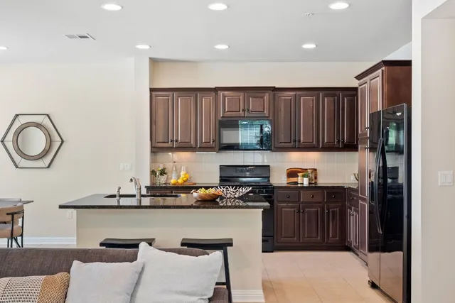 a kitchen with stainless steel appliances granite countertop a stove a sink and a microwave