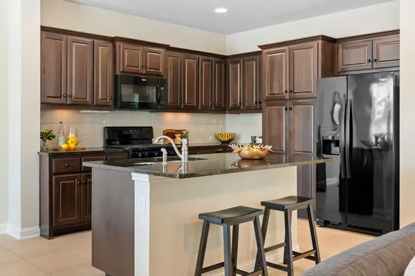 a kitchen with kitchen island cabinets a sink and a stove top oven with wooden floor