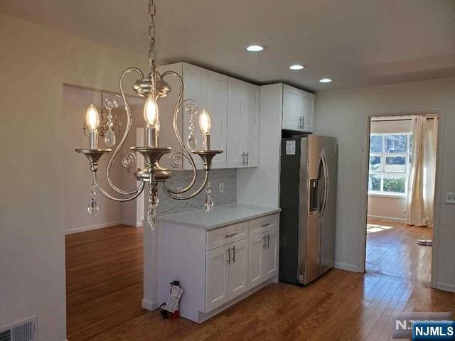 27 Ridge Road Cresskill, NJ 07626 - Photo 7 of 18 a kitchen with stainless steel appliances granite countertop a refrigerator a sink and a chandelier