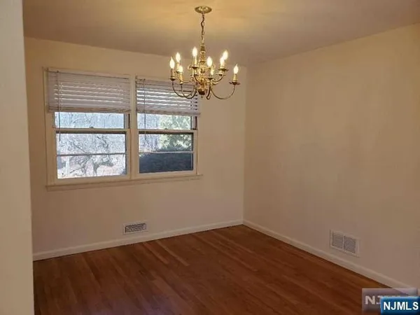 a view of a room with wooden floor and chandelier
