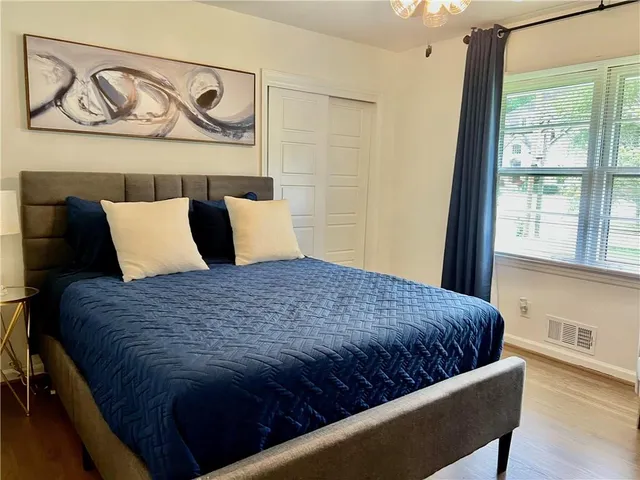 a bedroom with a bed and painting on the wall