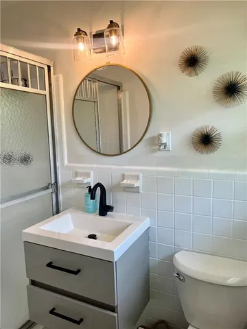 a bathroom with a sink mirror and toilet
