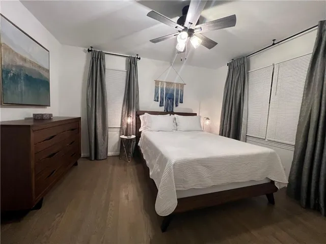 a bedroom with a bed dresser and a flat tv screen
