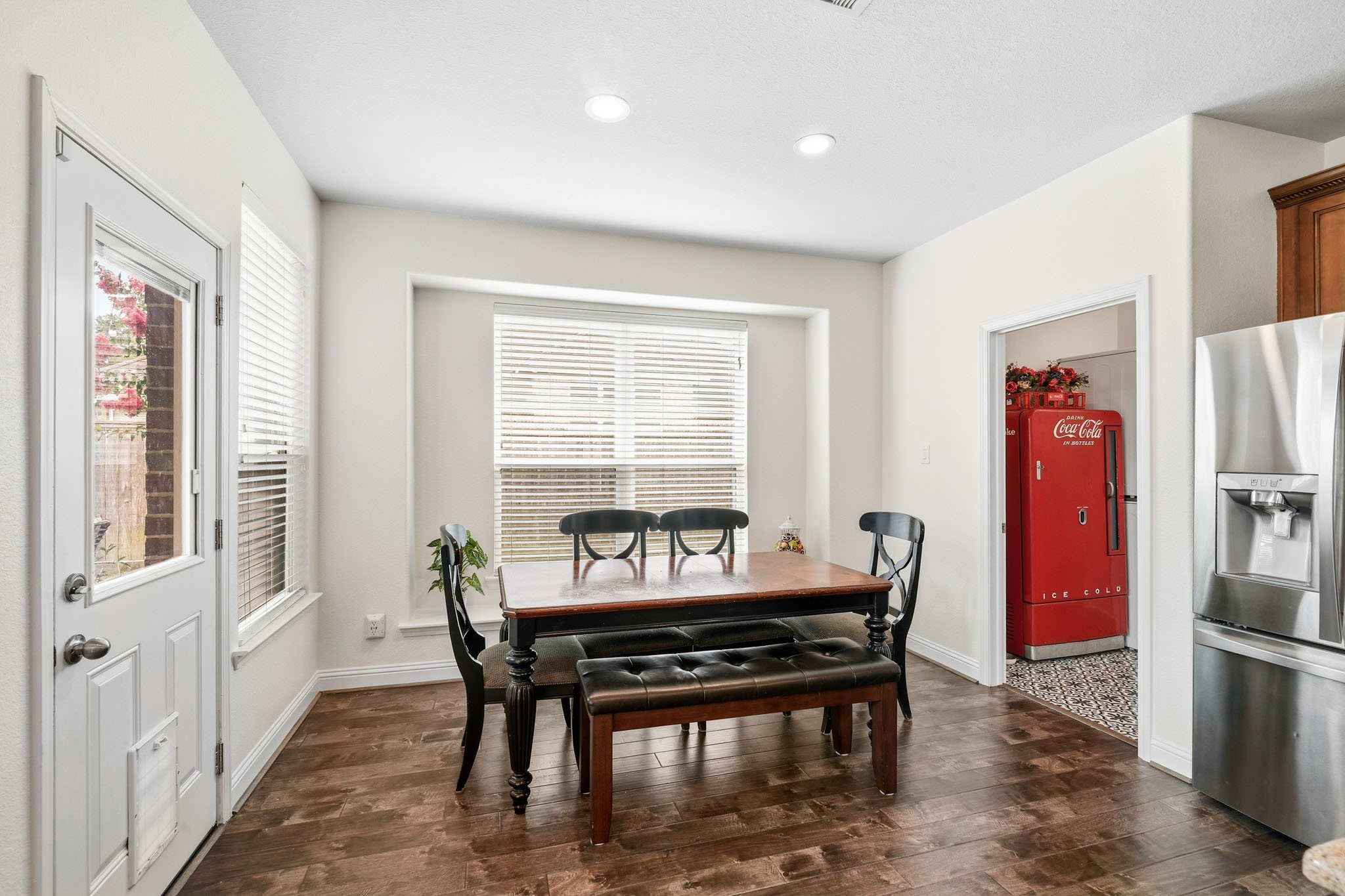17610 Strackfield Lane Tomball, TX 77377 - Photo 11 of 50 Bathed in natural light, this cheerful breakfast nook features a cozy window seat and seamless access to the patio through a glass door, blending indoor comfort with outdoor enjoyment. The laundry room sits to the right.