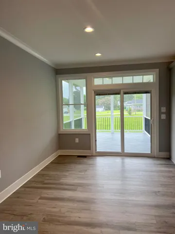 a view of a kitchen with a refrigerator and a wooden floor