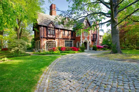 a view of a house with garden and large trees
