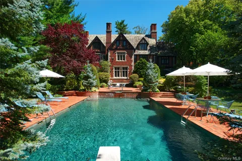 a front view of a house with swimming pool having outdoor seating