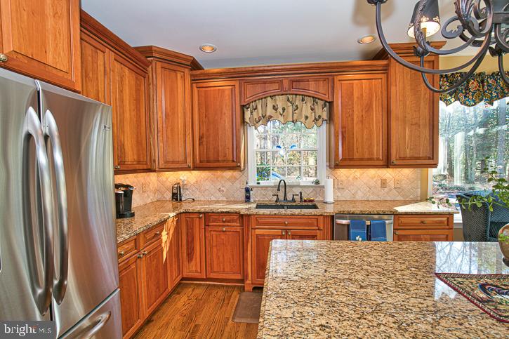 3589 Union Church Road Salisbury, MD 21804 - Photo 20 of 84 a kitchen with stainless steel appliances granite countertop a refrigerator a sink dishwasher and wooden cabinets with wooden floor