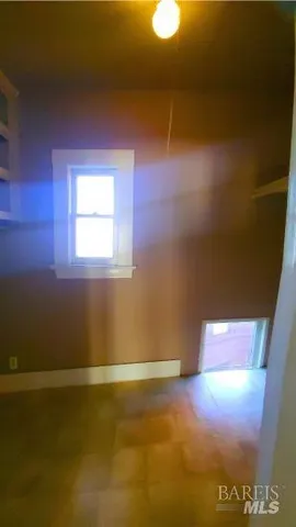 a view of kitchen with refrigerator and white cabinets