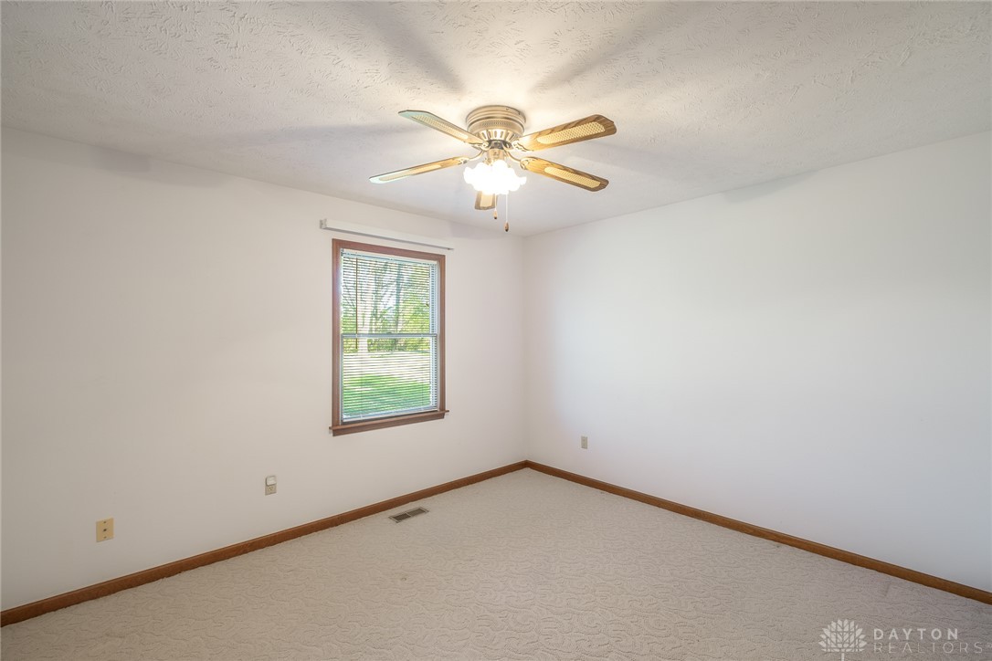 276 South Fairfield Road Bellbrook, OH 45305 - Photo 32 of 38 Bright and airy bedroom features soft carpeting and a window overlooking lush greenery.