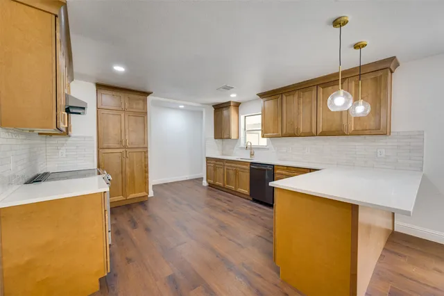 a kitchen with stainless steel appliances granite countertop a sink a stove a refrigerator a microwave oven with wooden floor