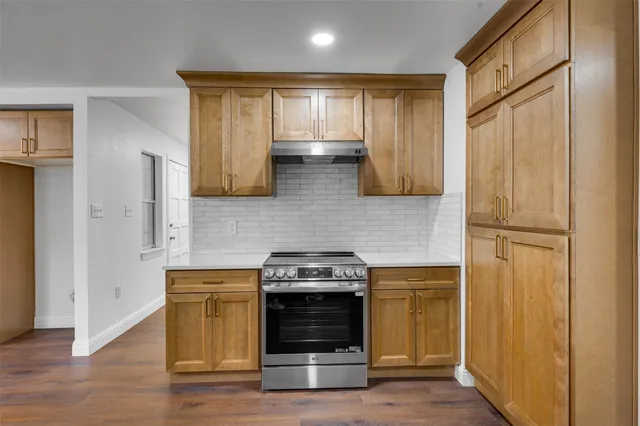 a kitchen with stainless steel appliances wooden floor sink and wooden cabinets
