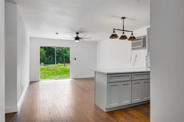 a view of a kitchen with a sink and dishwasher with wooden floor