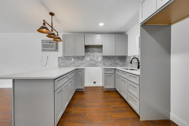 a kitchen with kitchen island granite countertop a sink and a stove top oven
