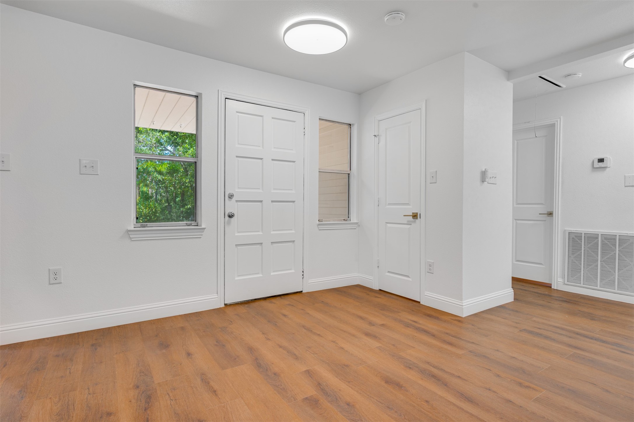 302 An County Road 3914 Palestine, TX 75801 - Photo 7 of 44 an empty room with wooden floor and windows