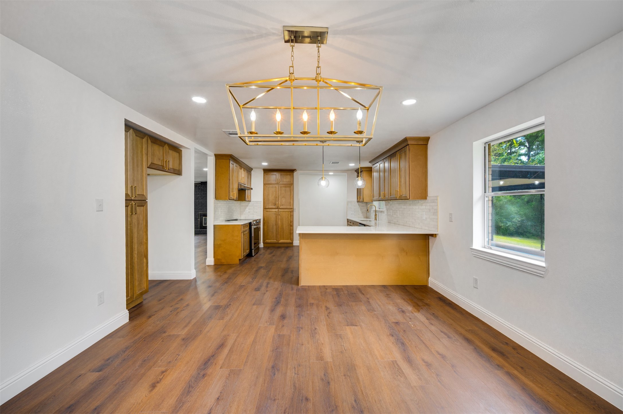 302 An County Road 3914 Palestine, TX 75801 - Photo 10 of 44 a large kitchen with stainless steel appliances granite countertop a dishwasher a stove a sink dishwasher and a fireplace with wooden floor