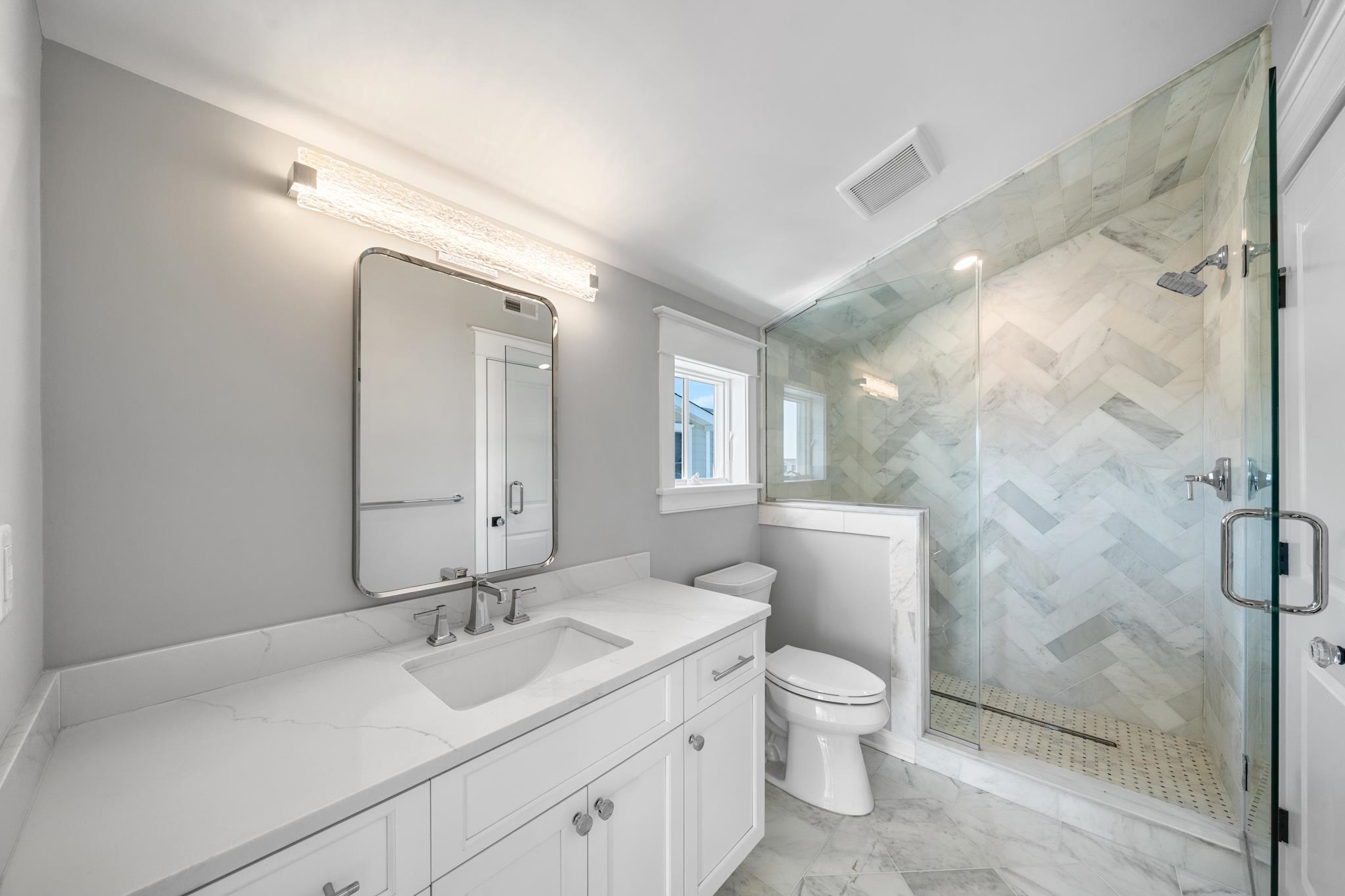 65 East 24th Avalon, NJ 08202 - Photo 47 of 49 a bathroom with a granite countertop sink toilet a large mirror and shower