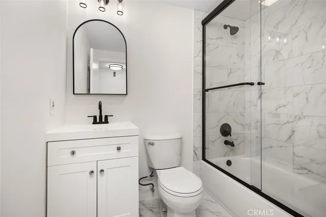 a bathroom with a toilet sink shower and mirror