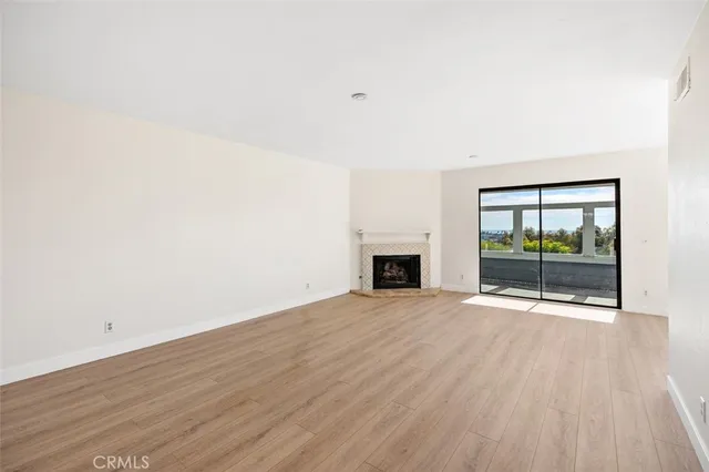 an empty room with wooden floor and fireplace