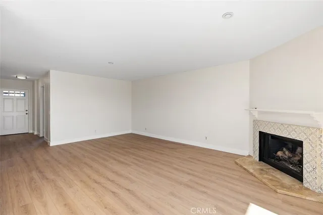 a view of empty room with wooden floor and fireplace