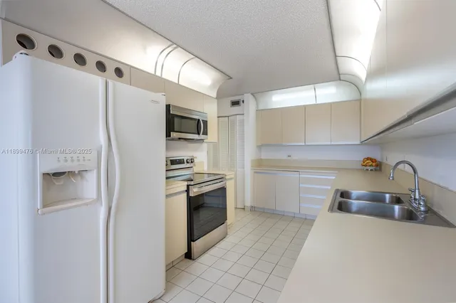 a kitchen with stainless steel appliances a refrigerator sink and stove