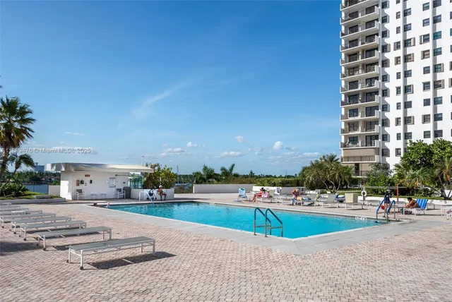 a view of a swimming pool with a yard and plants