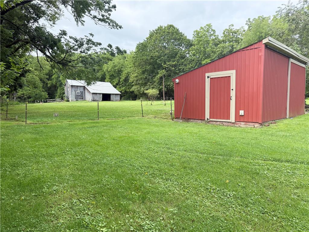 740 Engler Road Nazareth, PA 18064 - Photo 25 of 27 A vibrant red shed and rustic barn offer versatile utility on a verdant, open lot.