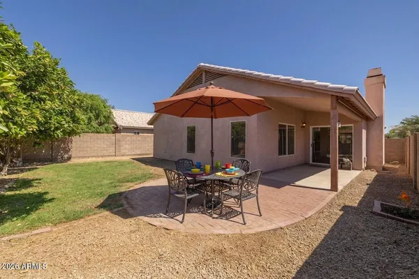 a patio with a table and chairs under an umbrella