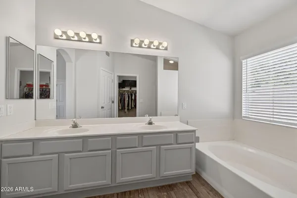 a bathroom with a sink double vanity granite tub and a mirror