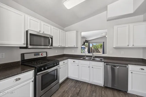 a kitchen with granite countertop white cabinets and white appliances
