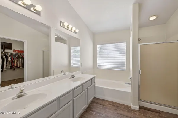 a bathroom with a tub a sink and a mirror