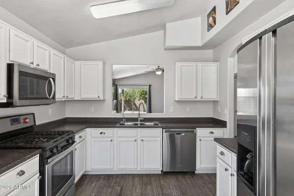 a kitchen with stainless steel appliances granite countertop a stove a sink and a refrigerator